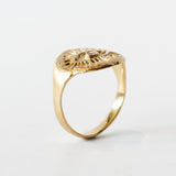 Yellow gold signet ring with hand carved eye design with a small diamond in the middle.