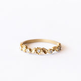 A floral motif diamond wedding band in yellow gold.
