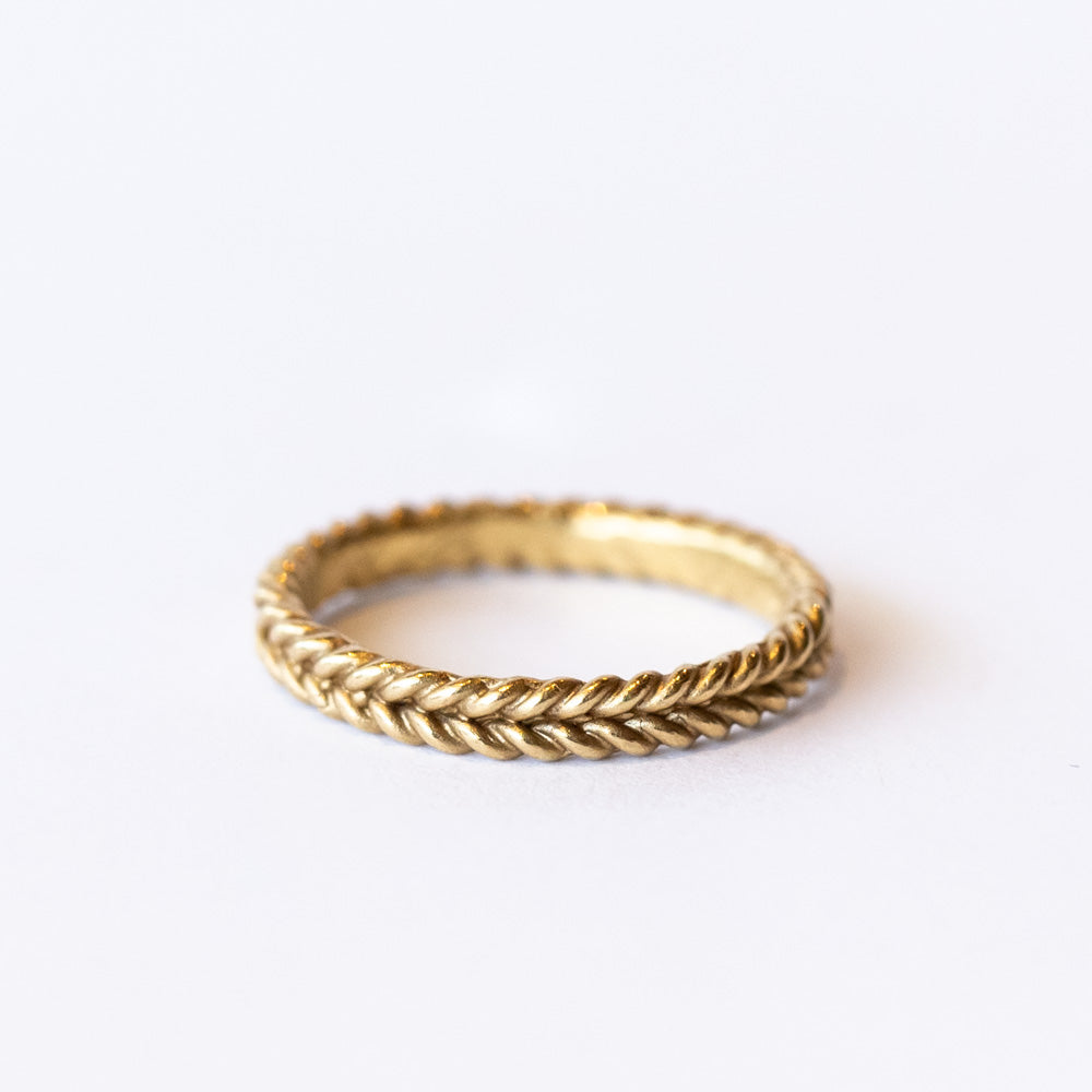 A yellow gold band featuring a woven rope pattern.