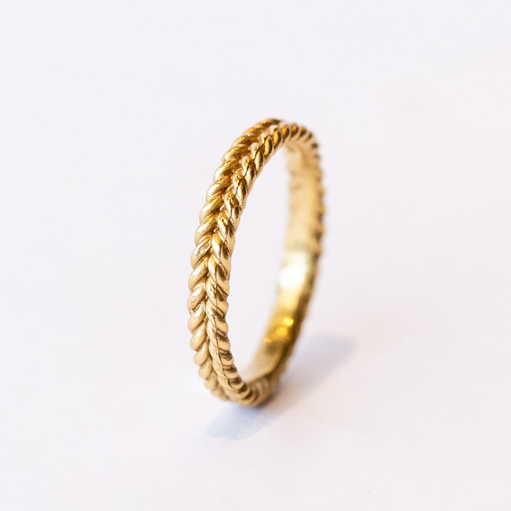 A yellow gold band featuring a woven rope pattern.