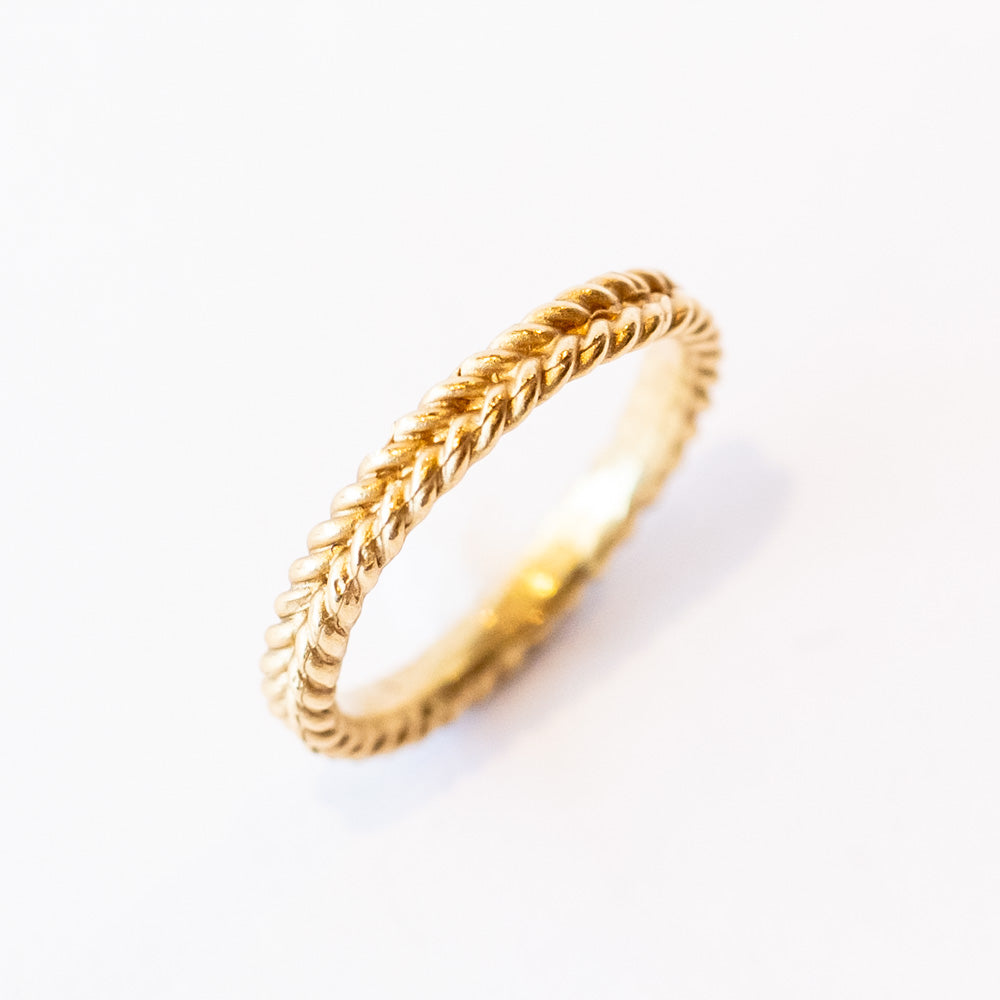A yellow gold band featuring a woven rope pattern.