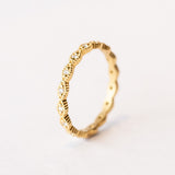 A yellow gold diamond eternity band with diamond shaped pattern all the way around, each shape is set with a small round diamond with milgrain bead edges.