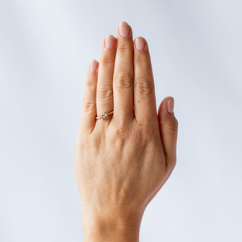 A dainty yellow gold and diamond cluster ring. On hand.