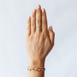 A textured yellow gold wedding band with flush set diamonds all the way around. On hand.