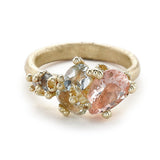 An asymmetrical gold cluster ring set with a variety of pastel gemstones amongst gold granules.