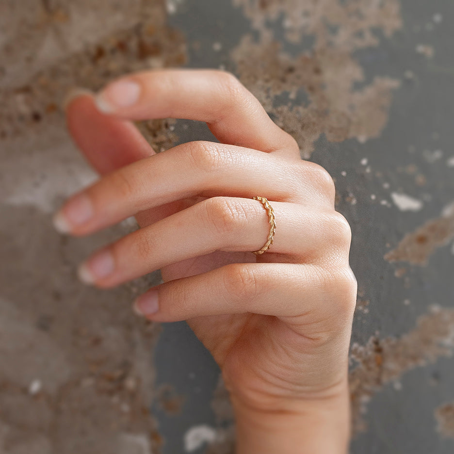 A carved laurel leaf pattern yellow gold wedding band. On hand.