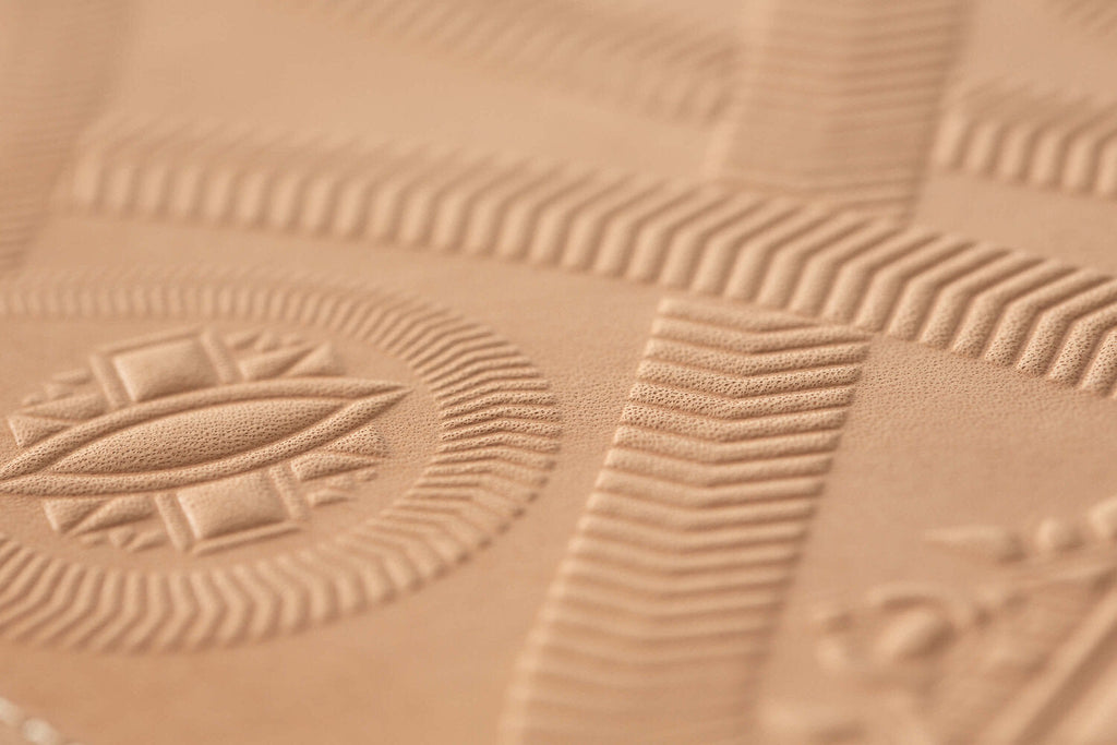 Leather tan zippered pouch hand stamped with snake design, detail of textured leather