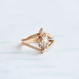 A yellow gold pointed contour wedding band set with a single row of tiny pave diamonds. With an engagement ring.