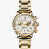 wide gold metal link bracelet watch, round white face with white hands