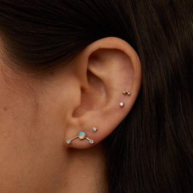 Wwake gold stud earring with opal and diamond on model, front view