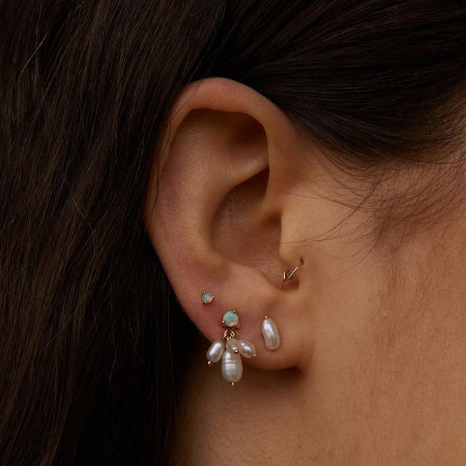 Wwake gold and opal earrings with dangling pearls on model, front view