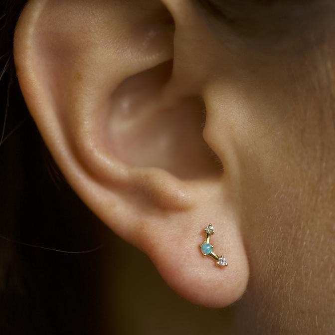 Wwake gold stud earring with opal and diamonds on model, front view