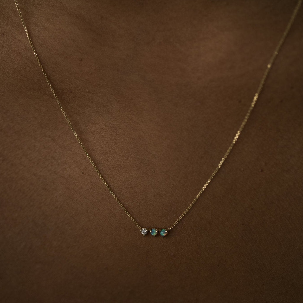 Wwake gold necklace with 1 diamond and 2 opals on model, front view