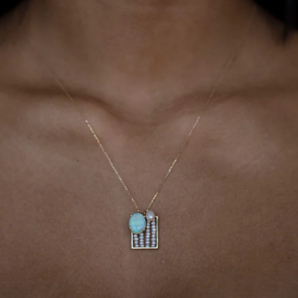 Wwake gold necklace with pearl and opal pendants on model, front view