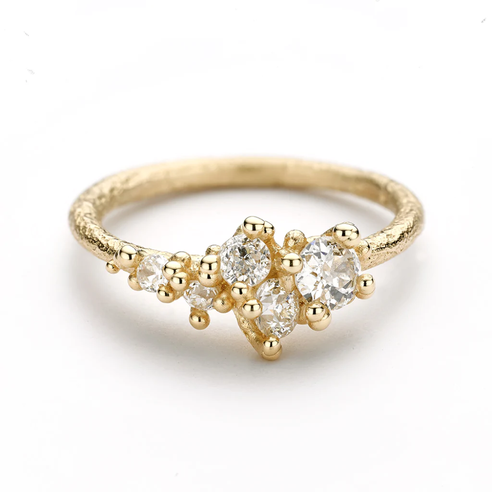 A tapering cluster of antique cut white diamonds all nestled amongst polished granules of rich yellow gold on a textured band.