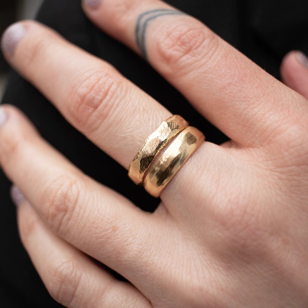 Page Sargisson thick gold wedding band set on model, top view