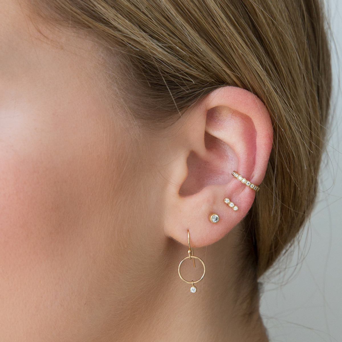 Zoe Chicco gold stud earring with 3 diamonds, on model, front view