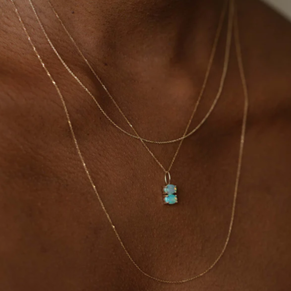 Wwake gold charm with two opals on chains on model, front view