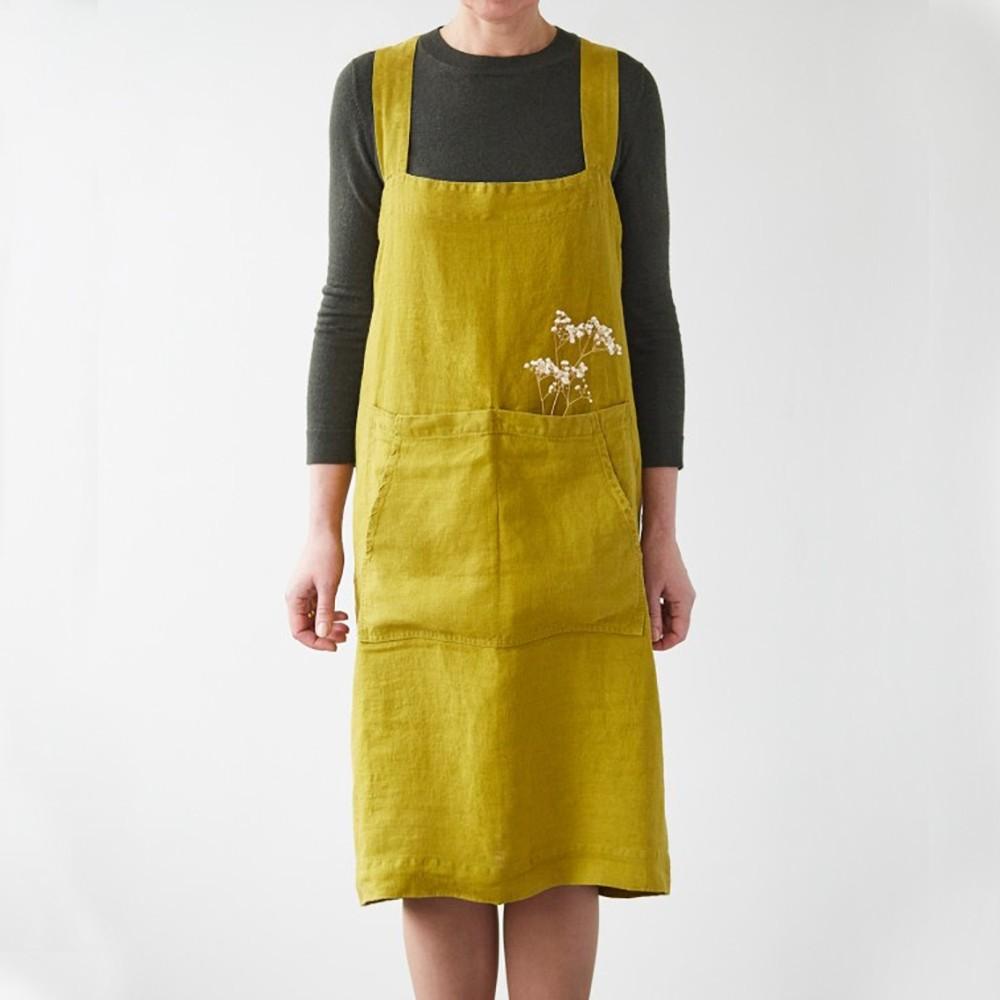 Linen Tales yellow green apron on model, front view