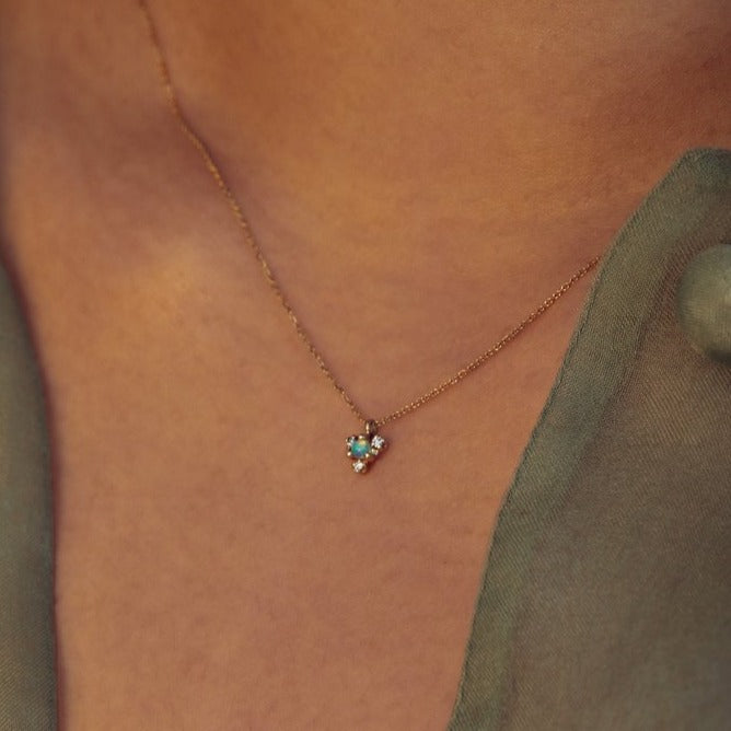 Wwake gold necklace with opal and diamonds on model, angled front view