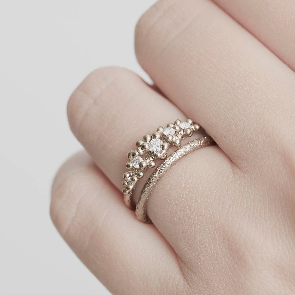 A classic narrow ladies' wedding band with an organic textured finish. On hand.