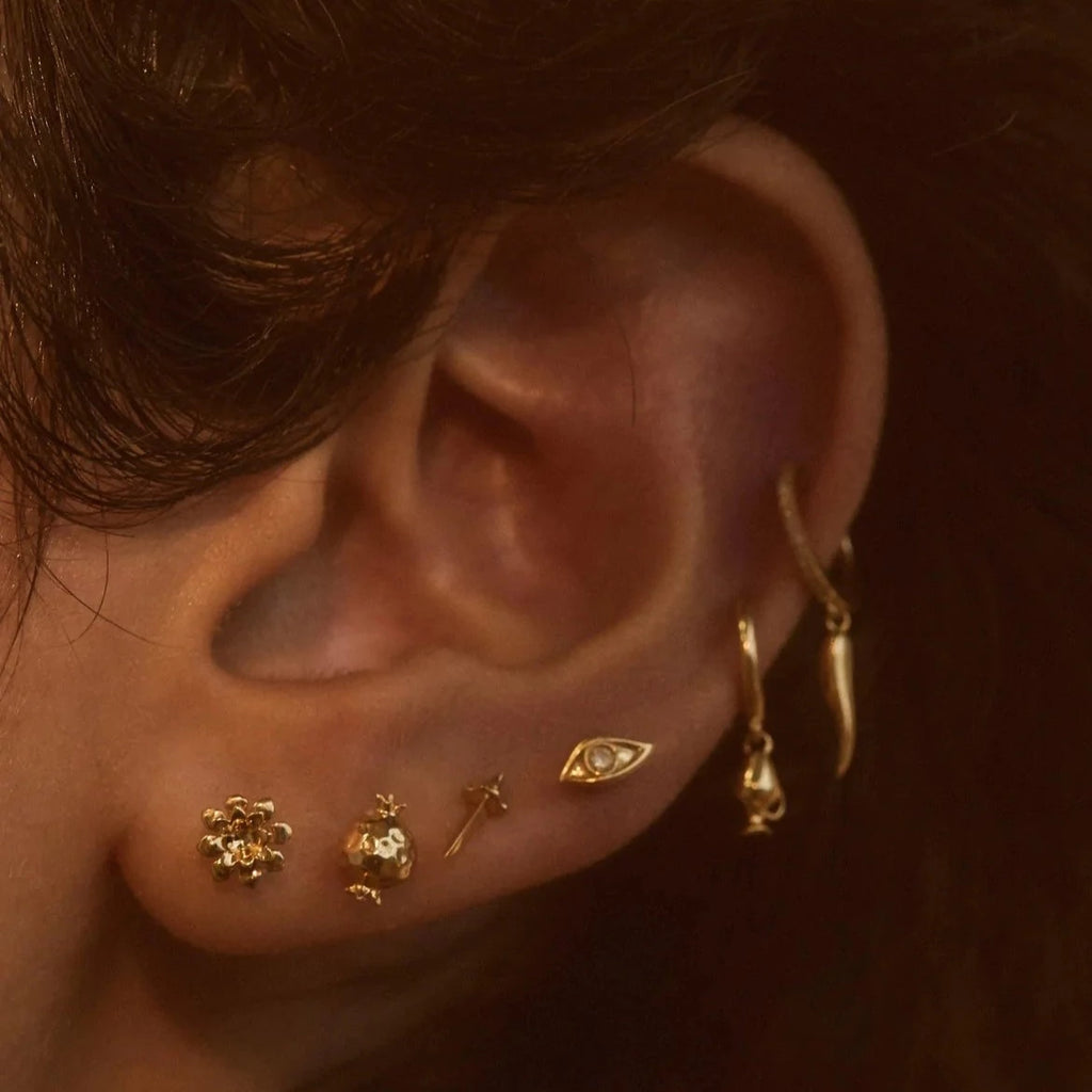 Pamela Love gold eye stud earring with diamond, on model, front view