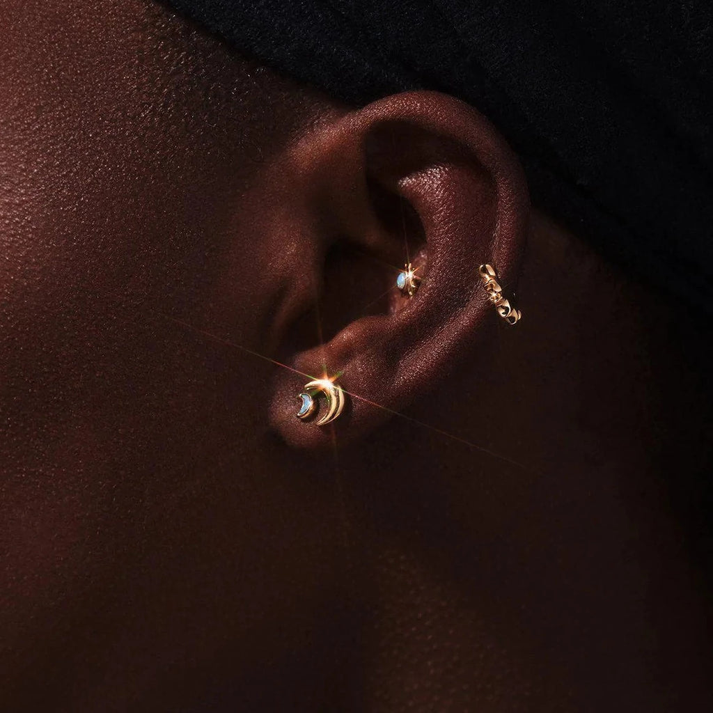 Pamela Love gold crescent moon stud earring, on model, front view