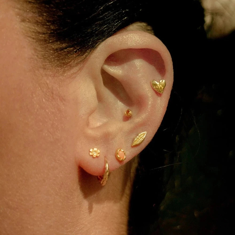 Pamela Love gold huggie earring with braid detail on model, front view