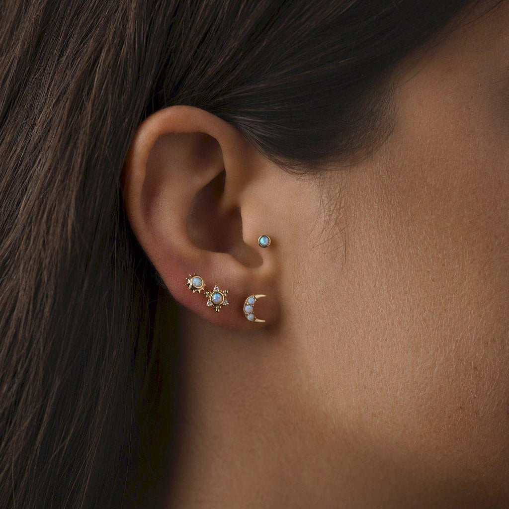 Pamela Love gold sun stud earring with opal, on model front view