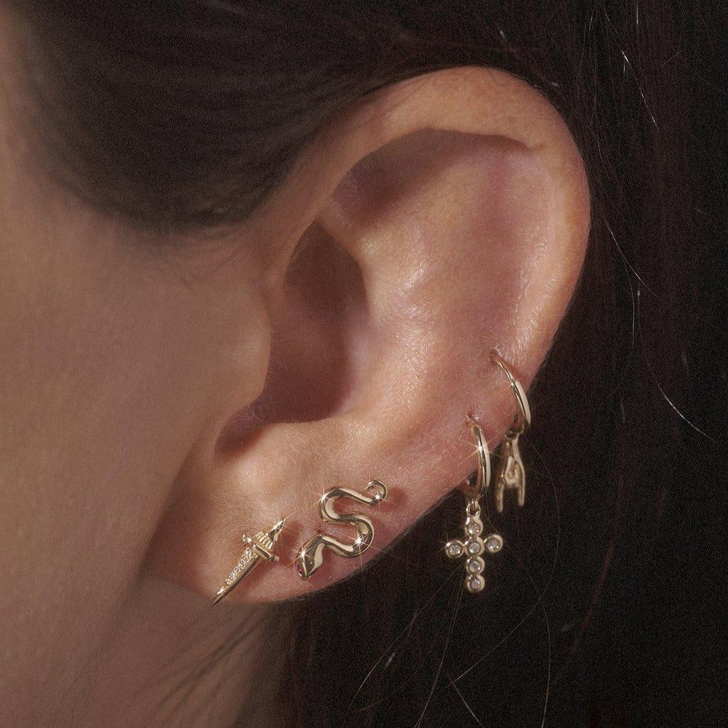 Pamela Love gold dagger stud earring with diamonds, on model, front view