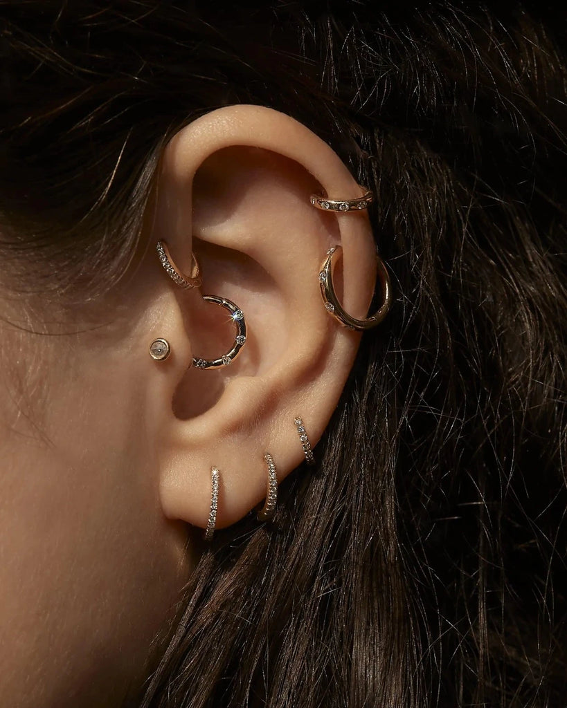 Pamela Love gold huggie earring with diamonds, on model, side view