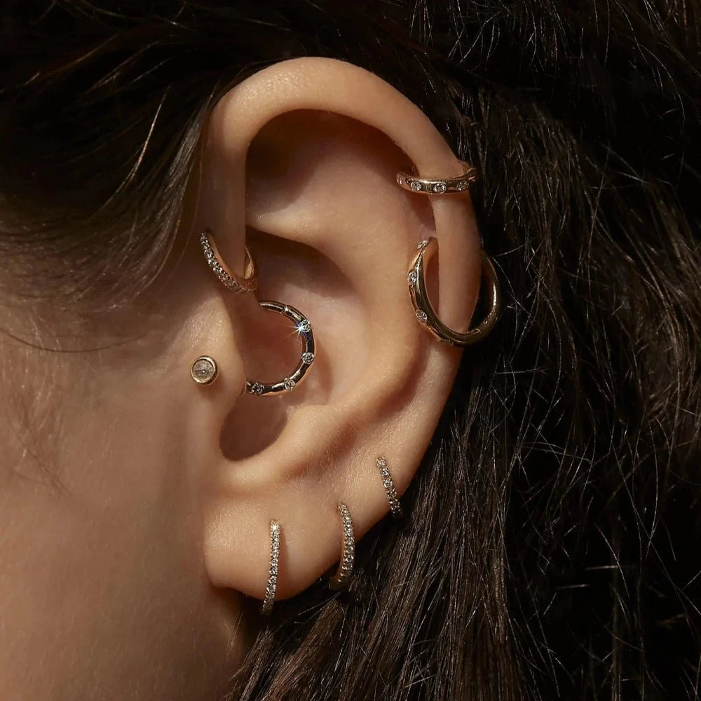 Pamela Love gold huggie earring with diamonds on model, side view