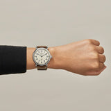 Shinola cream stainless steel watch with brown leather strap on model's arm, front view