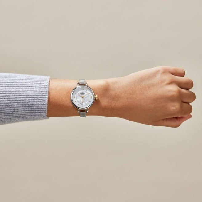 Shinola silver stainless steel watch on model's arm, front view