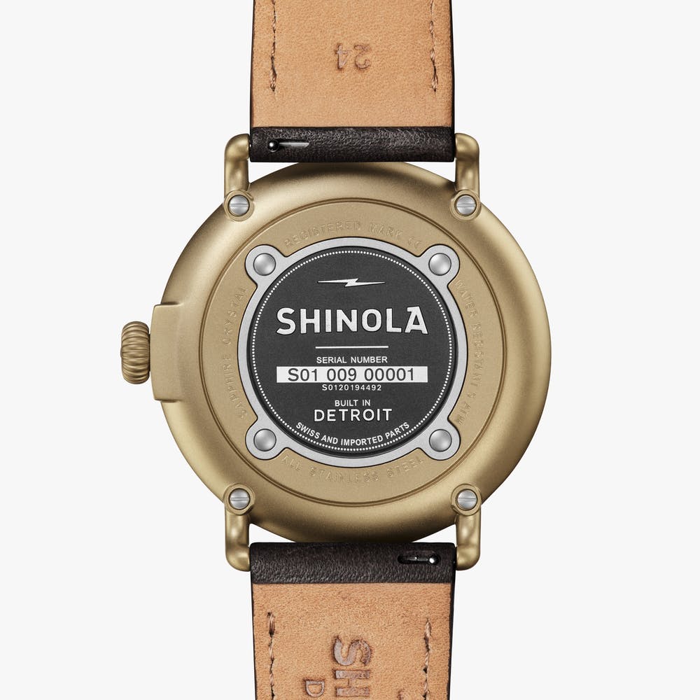 Shinola black watch face gold case with black leather strap, back view