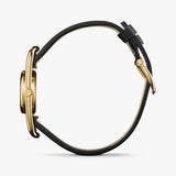 Shinola gold watch with black leather strap, side view