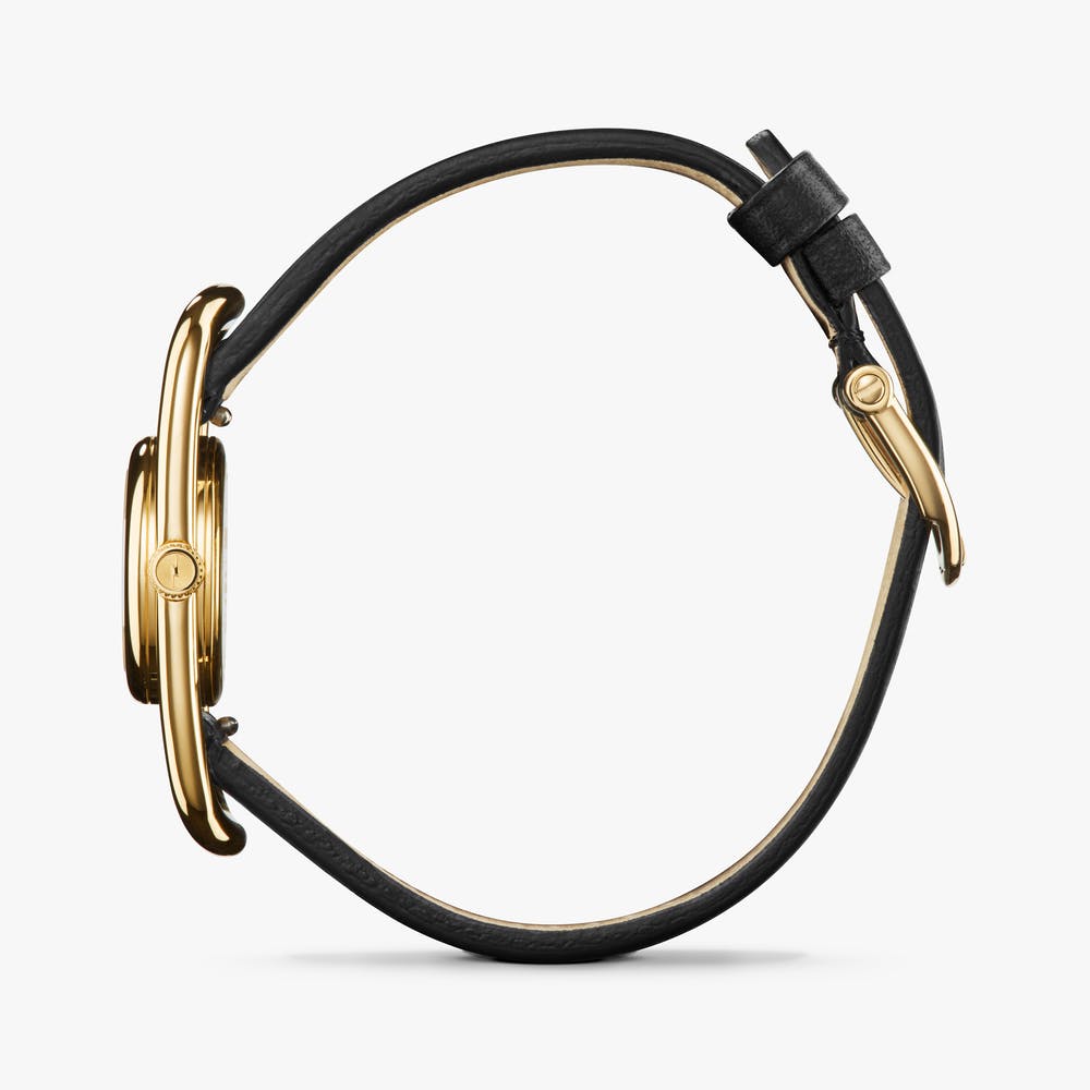 Shinola gold watch with black leather strap, side view