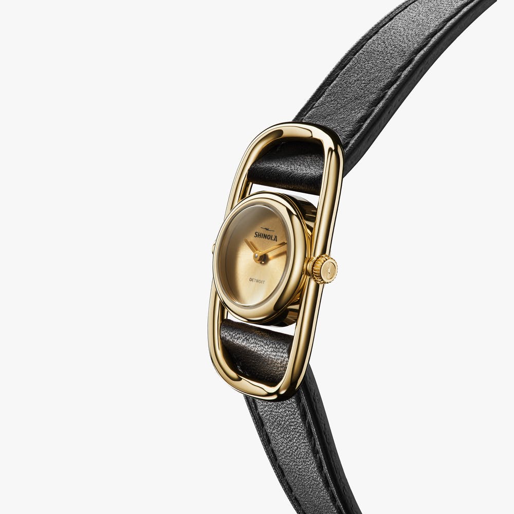 Shinola gold watch with black leather strap, angled front view