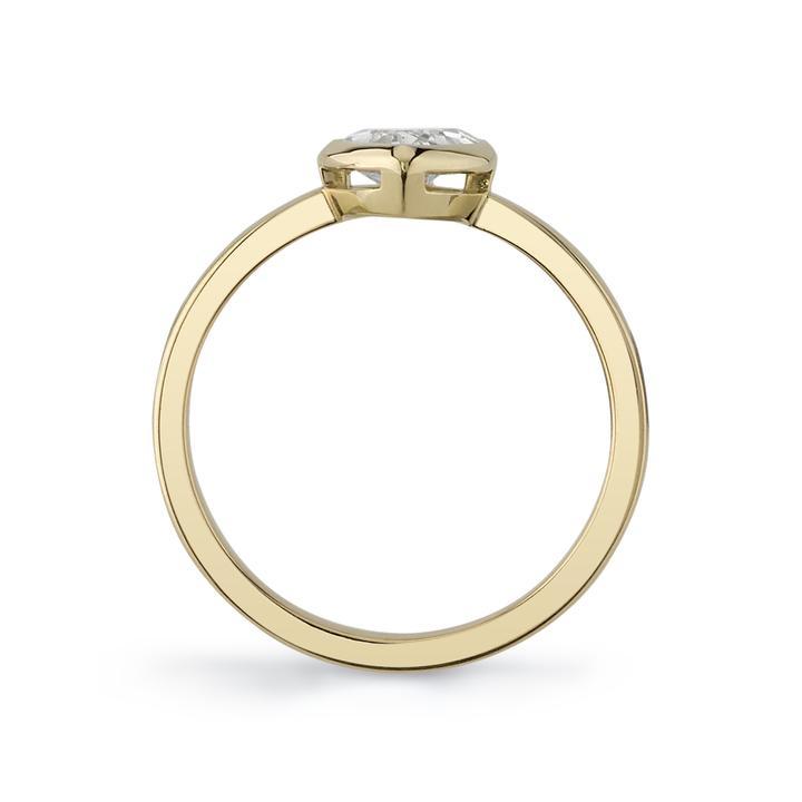 A pear-shaped diamond is bezel set in yellow gold on a solitaire engagement ring.
