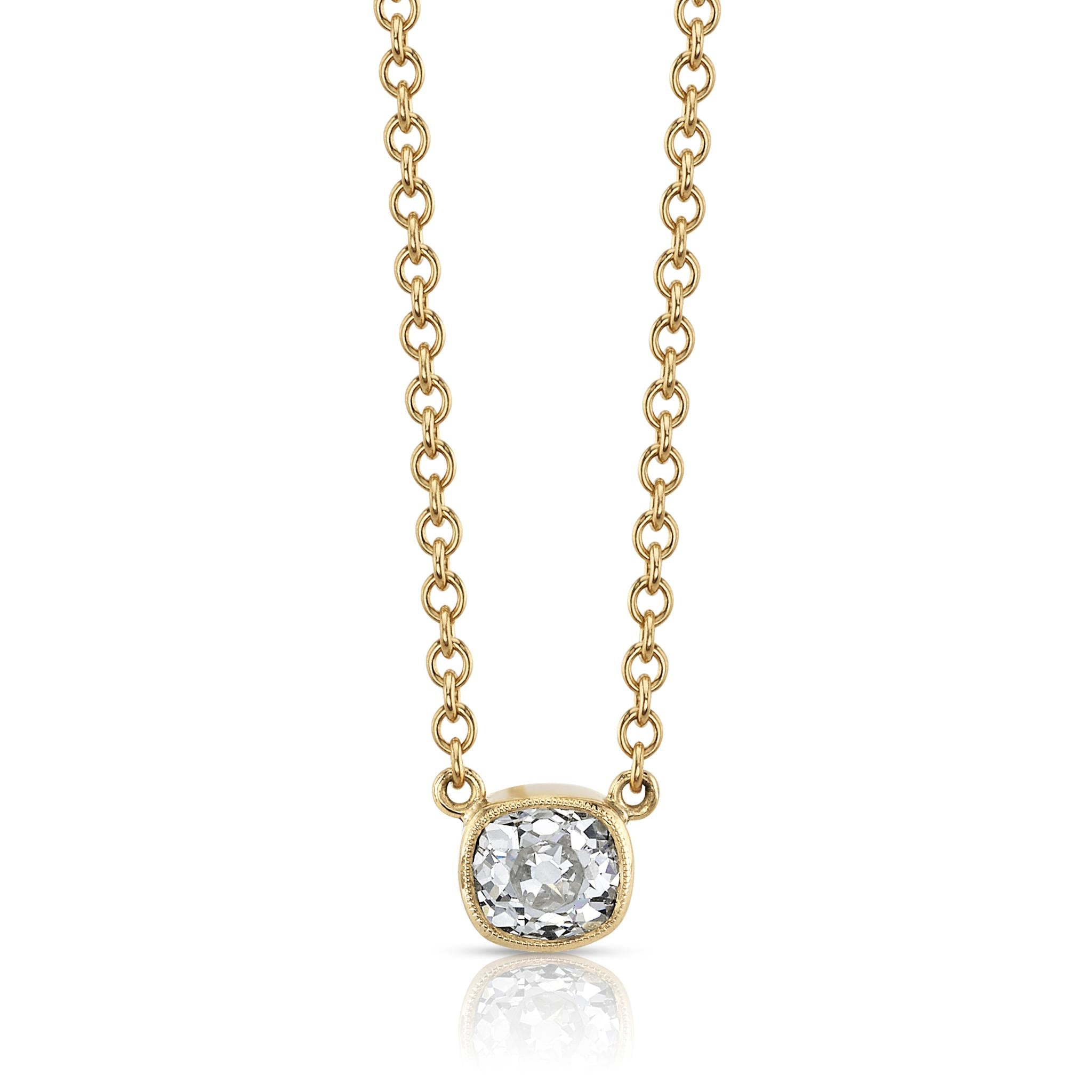 A bezel set cushion cut diamond in yellow gold on a cable chain necklace.