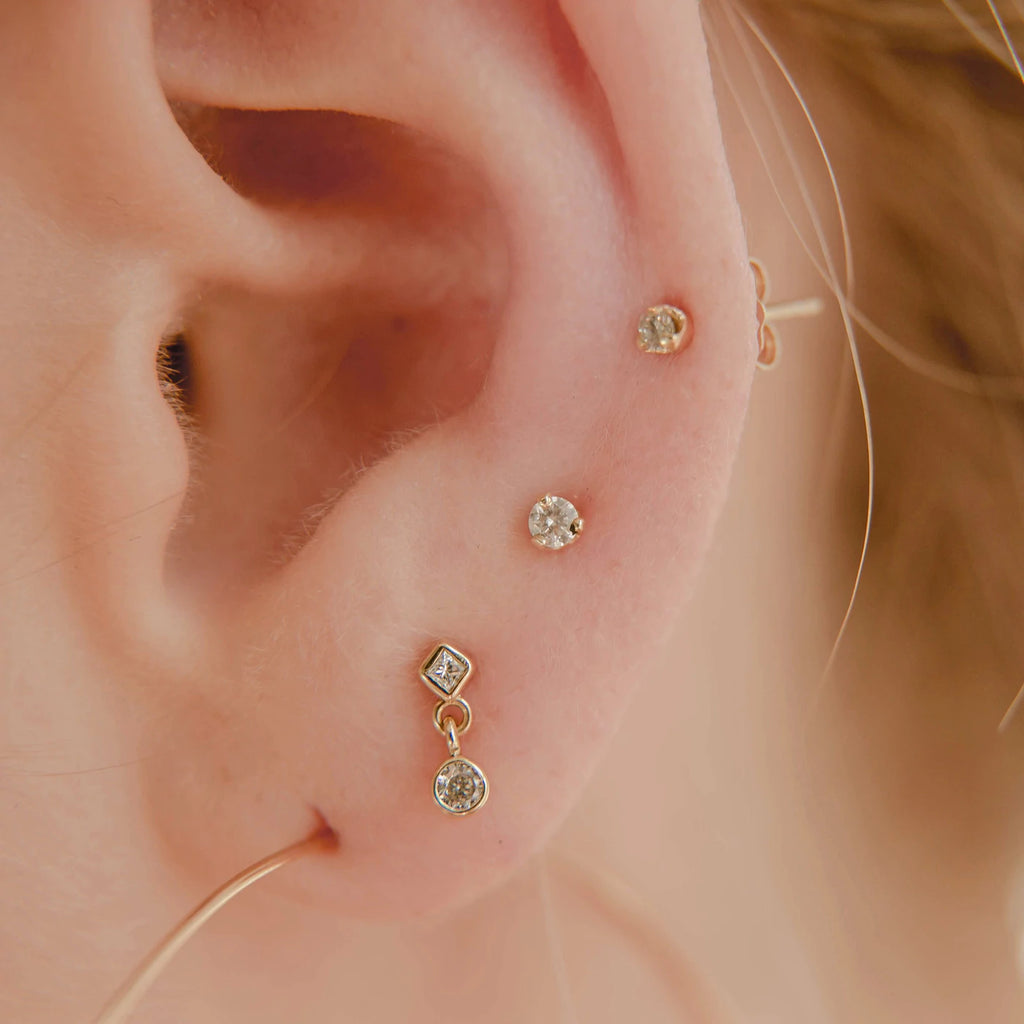 Zoe Chicco gold stud earrings with diamond drops, on model, front view