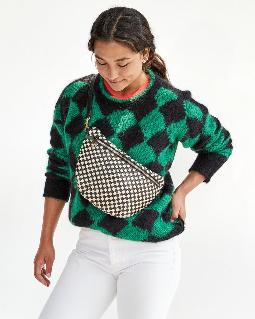 Clare V. black and white woven leather fanny pack on model, front view