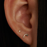 Wwake gold and diamond stud earring on model, front view