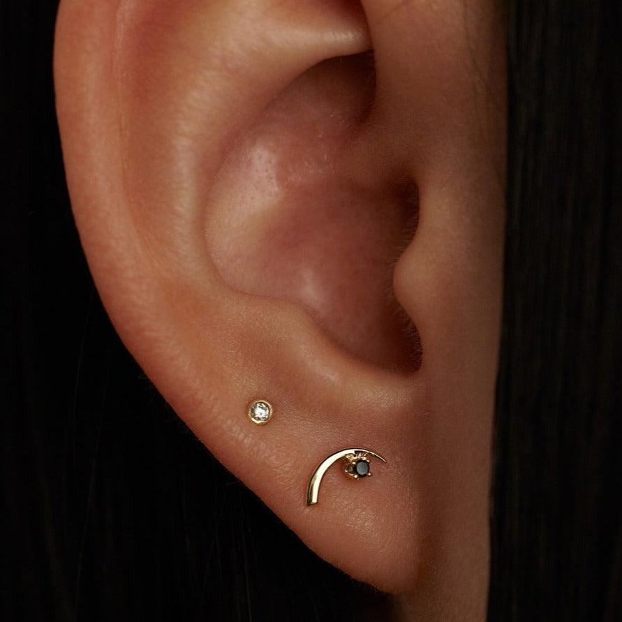 Wwake gold and diamond stud earring on model, front view