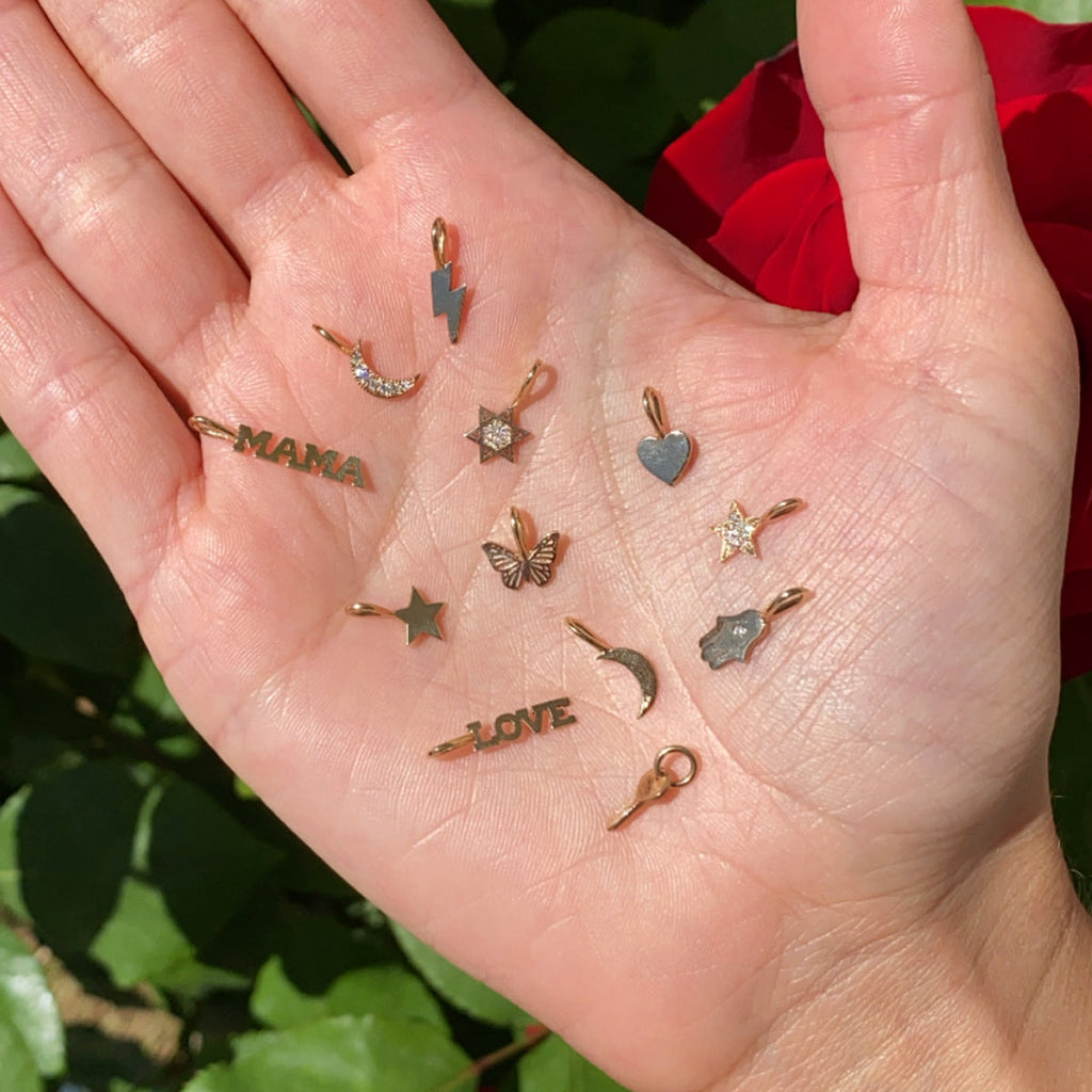 Zoe Chicco assorted charms on model's hand, front view