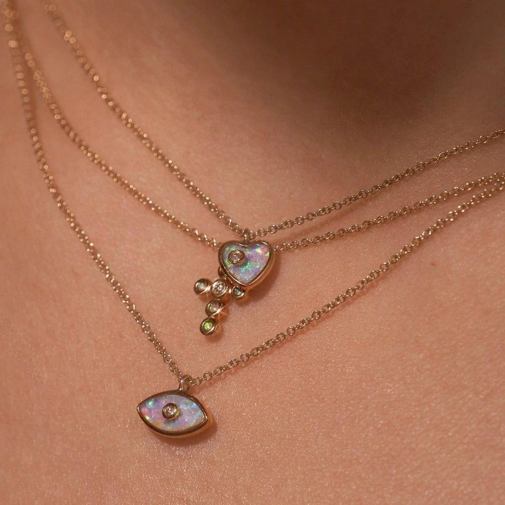Pamela Love gold necklace with eye pendant, opal and diamond, on model front view