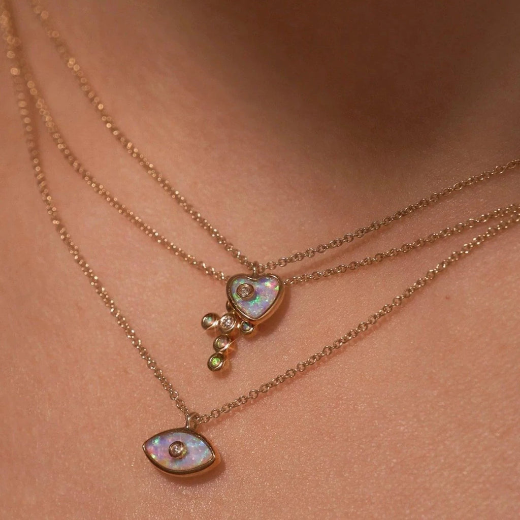 Pamela Love gold heart necklace with opal and diamond, on model front view