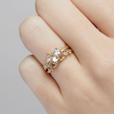 A tapering cluster of antique cut white diamonds all nestled amongst polished granules of rich yellow gold on a textured band.