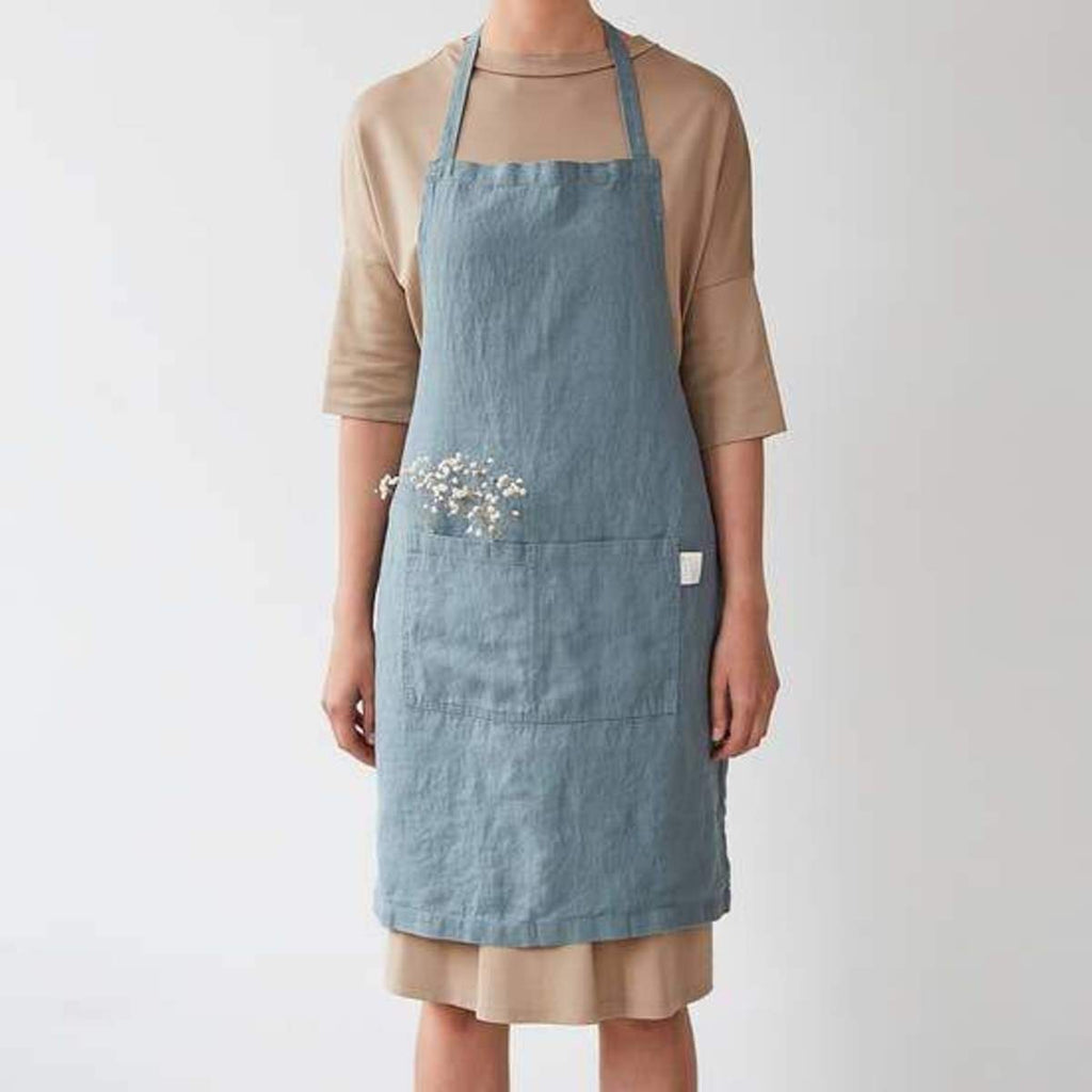 Linen Tales blue apron on model, front view