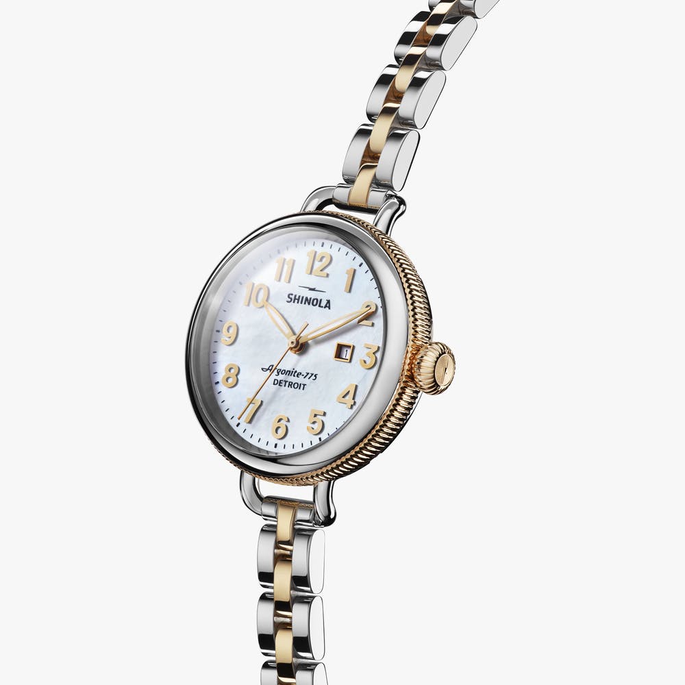 Shinola stainless steel silver and gold watch, angled front view